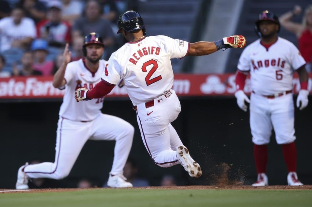 Los Angeles Angels' Luis Rengifo (2) scores off of an RBI single by Taylor Ward (3) as Nolan Schanuel and Willie Calhoun (5) watch during the first inning of a baseball game against the Colorado Rockies in Anaheim, Calif., Tuesday, July 30, 2024. (AP Photo/Jessie Alcheh)