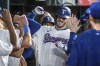Texas Rangers' Jonah Heim is congratulated in the dugout after hitting a three-run home run off Boston Red Sox starting pitcher Tanner Houck that also scored Ezequiel Duran and Josh Jung during the fourth inning of a baseball game Saturday, Aug. 3, 2024, in Arlington, Texas. (AP Photo/Jeffrey McWhorter)