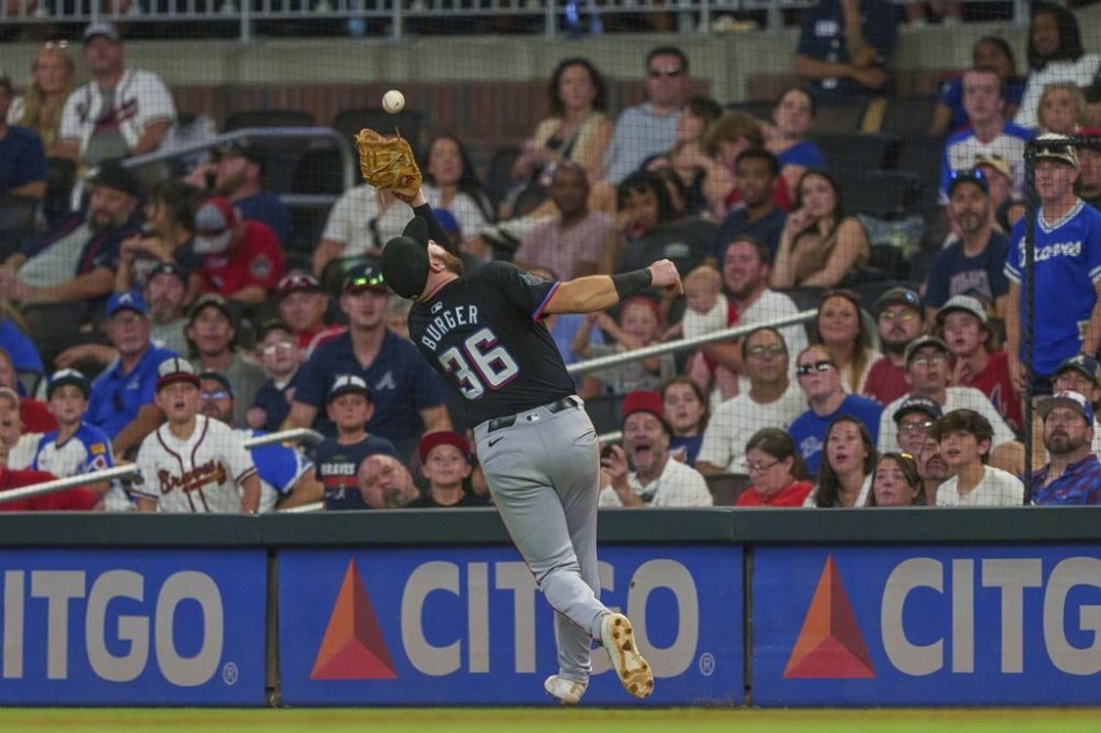 Miami Marlins first baseman Jake Burger (36) catches a pop fly foul ball in the ninth inning of a baseball game against the Atlanta Braves, Saturday, Aug. 3, 2024, in Atlanta. (AP Photo/Jason Allen)