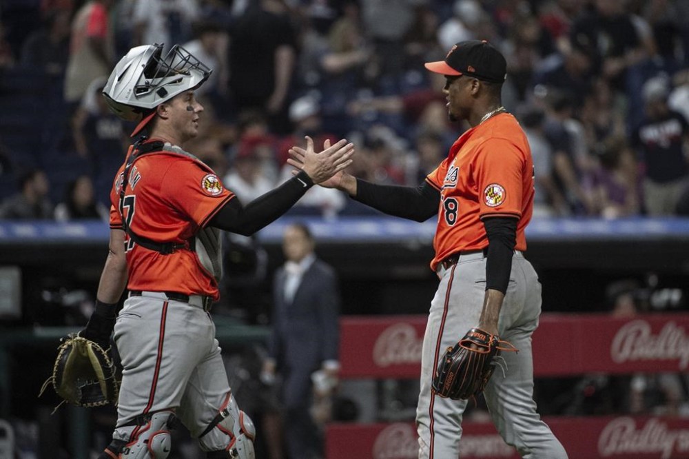 Baltimore Orioles' James McCann, left, congratulates reliever Yennier Cano at the end of a baseball game against the Cleveland Guardians in Cleveland, Saturday, Aug. 3, 2024. (AP Photo/Phil Long)