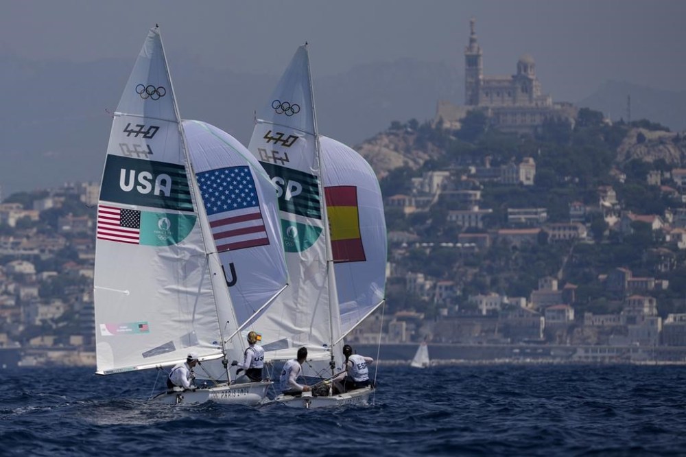 Lara Dallman-Weiss and Stuart McNay of the United States and Jordi Xammar Hernandez and Nora Brugman Cabot of Spain fly spinnakers during a 470 mixed dinghy class race the 2024 Summer Olympics, Friday, Aug. 2, 2024, in Marseille, France. (AP Photo/Carolyn Kaster)