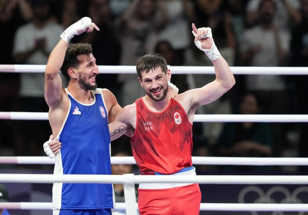 Canada's Wyatt Sanford, right, and Sofiane Oumiha of France react after the men's 63.5 kg semifinal boxing match at the 2024 Summer Olympics, Sunday, August 4, 2024 in Paris, France. THE CANADIAN PRESS/Christinne Muschi