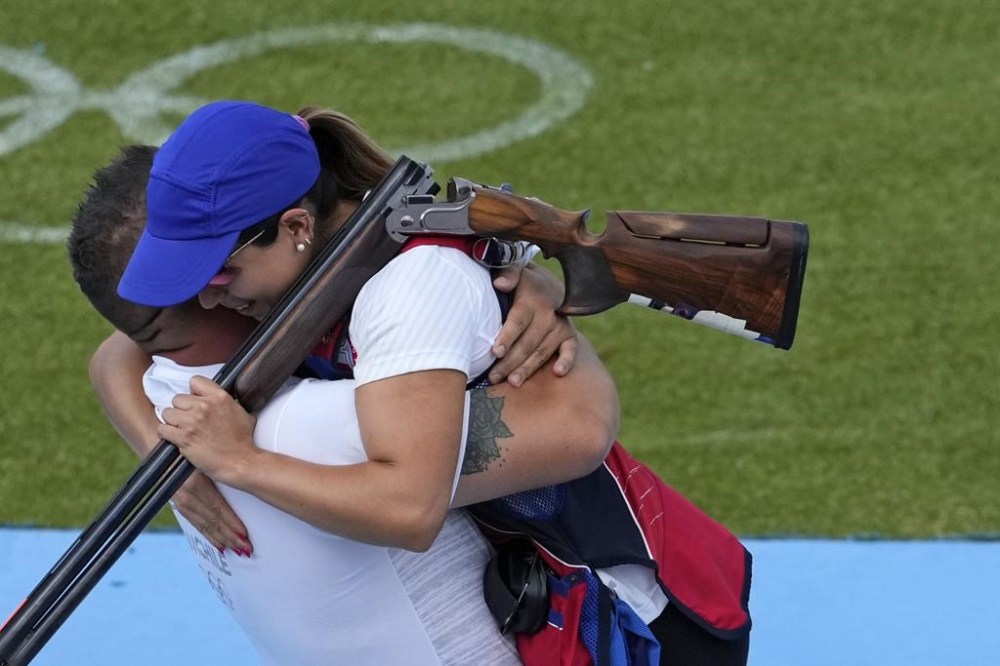 Chile's Francisca Crovetto Chadid, right, celebrates with coach after winning the gold medal in the Skeet women's final at the 2024 Summer Olympics, Sunday, Aug. 4, 2024, in Chateauroux, France. (AP Photo/Manish Swarup)