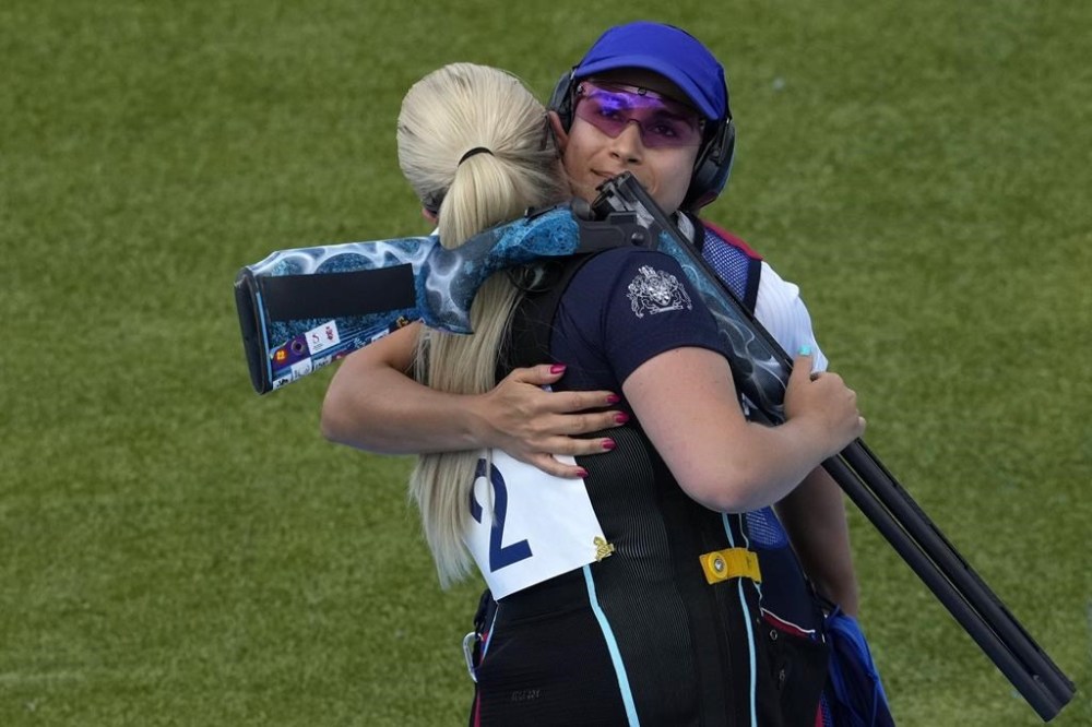 Silver medalist Britain's Amber Jo Rutter, left, hugs Chile's Francisca Crovetto Chadid after the latter won the gold medal in the Skeet women's final at the 2024 Summer Olympics, Sunday, Aug. 4, 2024, in Chateauroux, France. (AP Photo/Manish Swarup)