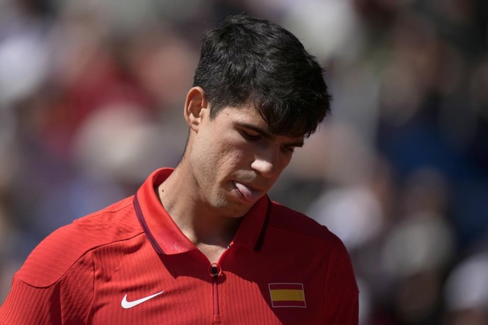 Spain's Carlos Alcaraz sticks his tongue out as he plays Serbia's Novak Djokovic during the men's singles tennis final at the Roland Garros stadium during the 2024 Summer Olympics, Sunday, Aug. 4, 2024, in Paris, France. (AP Photo/Louise Delmotte)