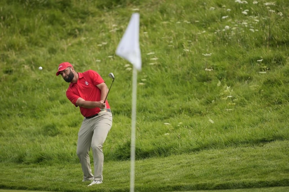 Jon Rahm, of Spain, chips onto the 14th green during the final round of the men's golf at the 2024 Summer Olympics, Sunday, Aug. 4, 2024, at Le Golf National in Saint-Quentin-en-Yvelines, France. (AP Photo/Matt York)