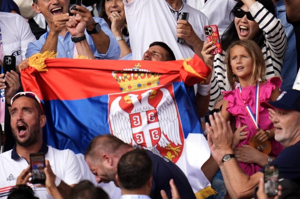 Serbia's Novak Djokovic holds his national flag after defeating Spain's Carlos Alcaraz in the men's singles tennis final at the Roland Garros stadium during the 2024 Summer Olympics, Sunday, Aug. 4, 2024, in Paris, France. (AP Photo/Manu Fernandez)