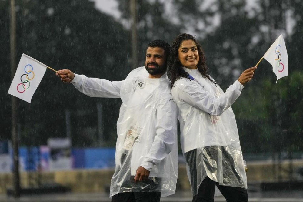 Judo competitors Mohammad Rashnonezhad, left, and Nigara Shaheen, both of the Olympic refugee team, pose for a photograph in Paris, France, during the opening ceremony of the 2024 Summer Olympics, Friday, July 26, 2024. THE CANADIAN PRESS/AP-Andy Wong