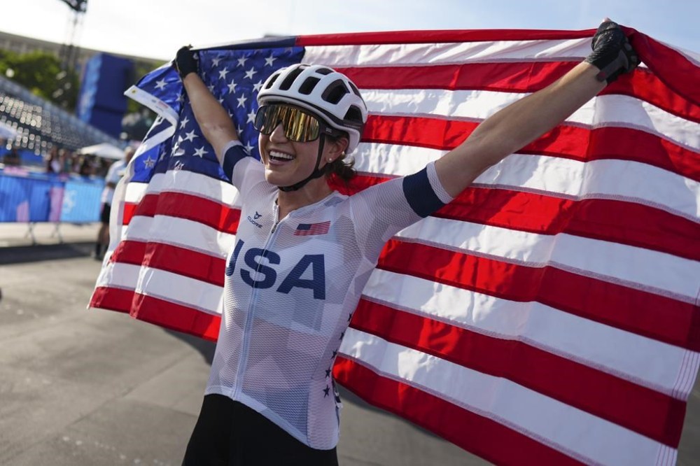 Kristen Faulkner, of the United States, celebrates winning the women's road cycling event, at the 2024 Summer Olympics, Sunday, Aug. 4, 2024, in Paris, France. (AP Photo/Thibault Camus)