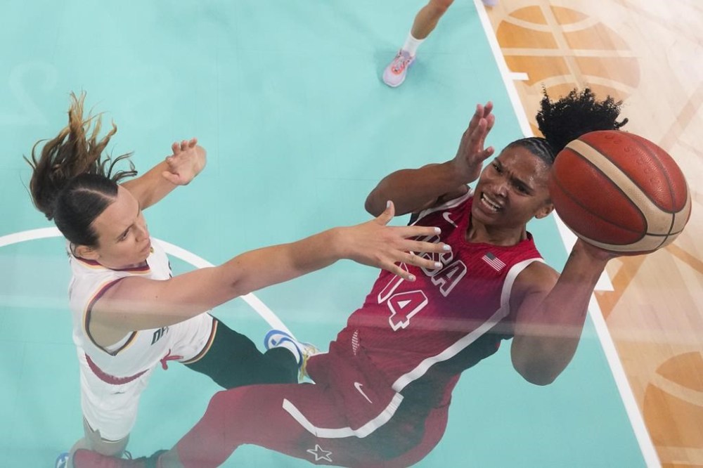Alyssa Thomas (14), of the United States, shoots over Emily Bessoir (22), of Germany, in a women's basketball game at the 2024 Summer Olympics, Sunday, Aug. 4, 2024, in Villeneuve-d'Ascq, France. (AP Photo/Mark J. Terrill, Pool)