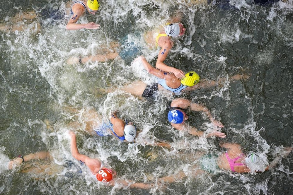 FILE - Australia's Natalie Van Coevorden (15), Belgium's Claire Michel (5) and Ekaterina Shabalina, of Kazakhstan (32) compete in the swim leg of the women's individual triathlon competition at the 2024 Summer Olympics, Wednesday, July 31, 2024, in Paris, France. Belgium's Olympic committee announced Sunday Aug.4, 2024 that it would withdraw its team from the mixed relay triathlon at the Paris Olympics after one of its competitors who swam in the Seine River fell ill. Claire Michel, who competed in the women's triathlon Wednesday,