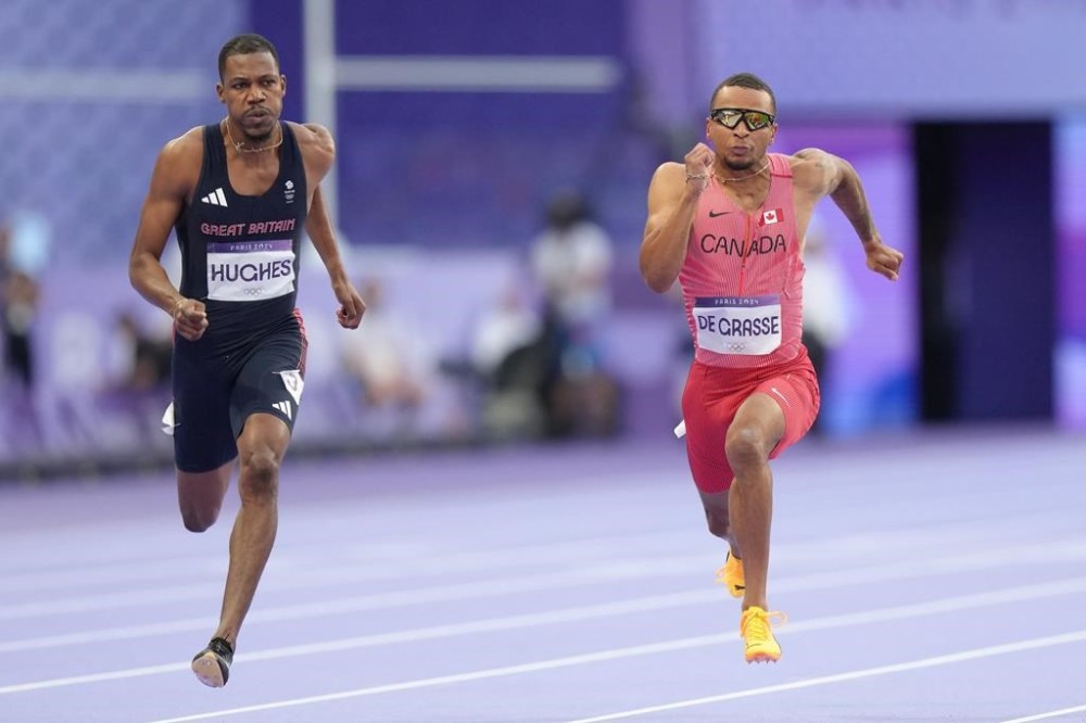 Sprinter Andre De Grasse, of Markham, Ont., right, competes in the men’s 100m semi-finals at the 2024 Summer Olympics, Sunday, Aug. 4, 2024, in Saint-Denis, France. THE CANADIAN PRESS/Nathan Denette