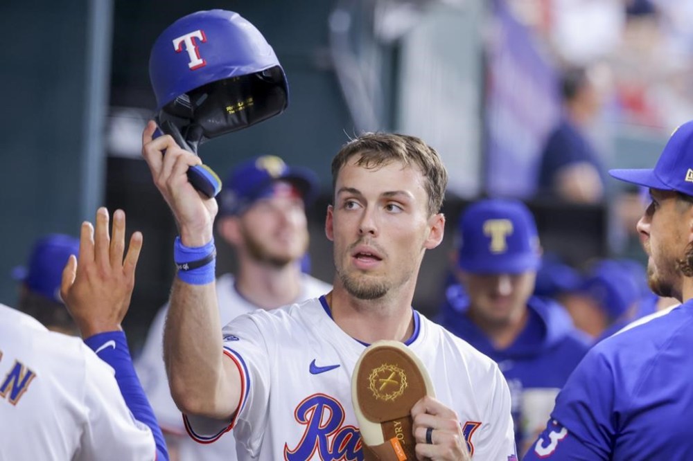 FILE - Texas Rangers' Evan Carter celebrates in the dugout during a game against the Chicago Cubs, March 31, 2024, in Arlington, Texas. Carter is unlikely to return in what was supposed to be the outfielder's first full season in the majors due to a nagging back injury general manager Chris Young said Tuesday, July 30, 2024. (AP Photo/Gareth Patterson, File)
