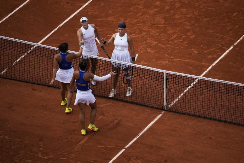 Sara Errani and Jasmine Paolini of Italy shake hands with Mirra Andreeva and Diana Shnaider of Individual Neutral Athlete after the women's doubles gold medal tennis match at the Roland Garros stadium, at the 2024 Summer Olympics, Sunday, Aug. 4, 2024, in Paris, France. (AP Photo/Louise Delmotte)