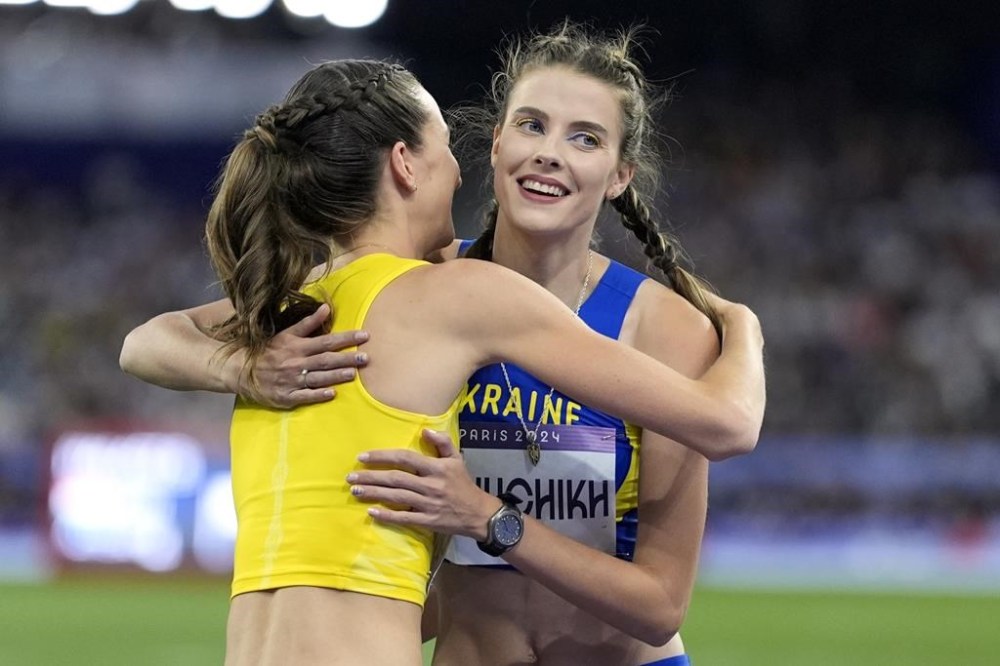 Yaroslava Mahuchikh, right, of Ukraine, is congraulated by Nicola Olyslagers, of Australia, left, after winning the women's high jump final at the 2024 Summer Olympics, Sunday, Aug. 4, 2024, in Saint-Denis, France. (AP Photo/Matthias Schrader)