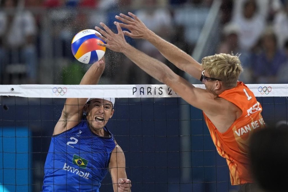 Brazil's Arthur Diego Mariano Lanci smashes the ball by Netherland's Steven van de Velde in a beach volleyball match at the 2024 Summer Olympics, Sunday, Aug. 4, 2024, in Paris, France. (AP Photo/Robert F. Bukaty)