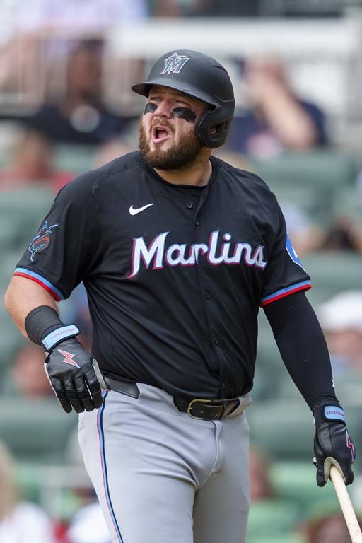 Miami Marlins' Jake Burger looks at the scoreboard for an instant replay after striking out in the sixth inning a baseball game against the Atlanta Braves, Sunday, Aug. 4, 2024, in Atlanta. (AP Photo/Jason Allen)