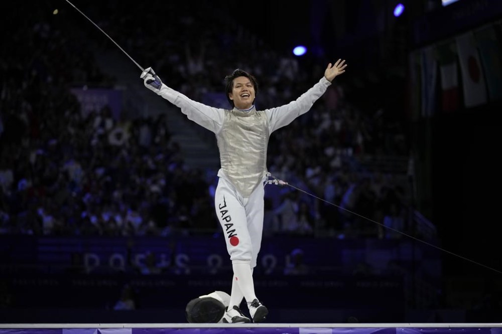 Japan's Kazuki Iimura celebrates after winning the men's team foil final match against Italy during the 2024 Summer Olympics at the Grand Palais, Sunday, Aug. 4, 2024, in Paris, France. (AP Photo/Andrew Medichini)