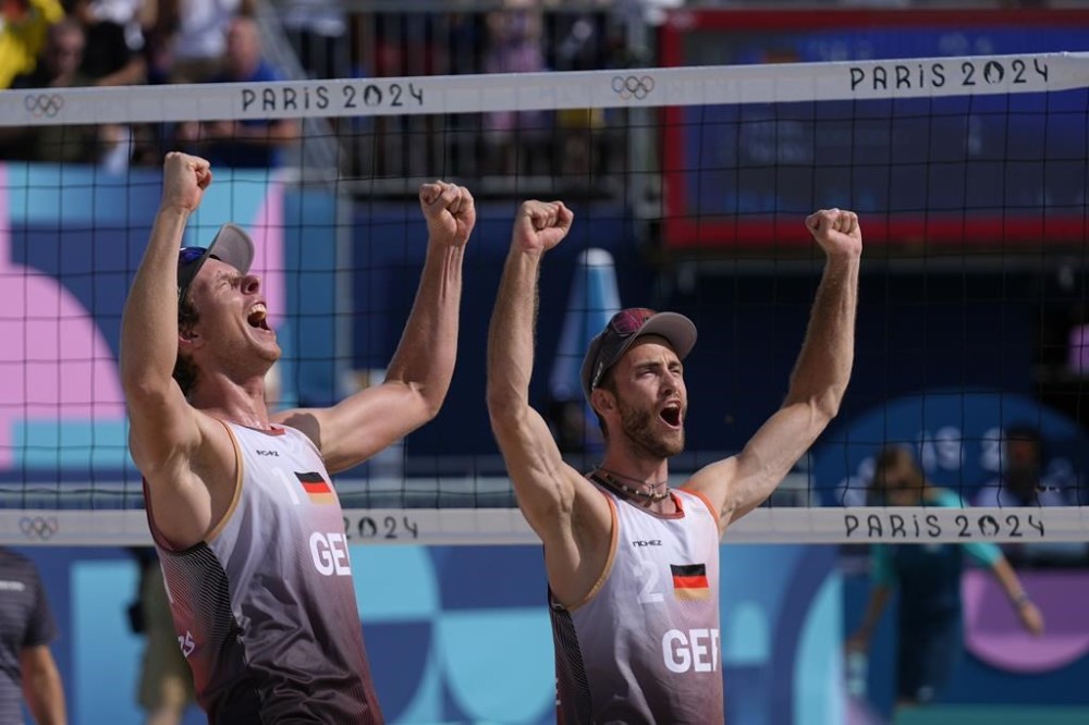 Germany's Nils Ehlers, left, and Clemens Wickler celebrate their victory over Brazil in a beach volleyball match at the 2024 Summer Olympics, Sunday, Aug. 4, 2024, in Paris, France. (AP Photo/Robert F. Bukaty)