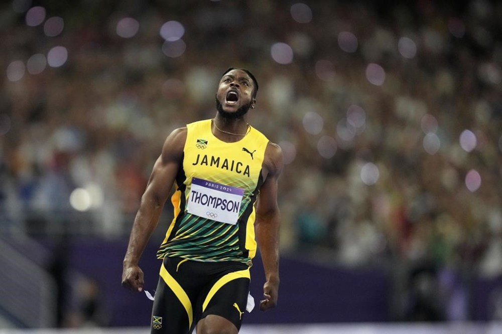 Kishane Thompson, of Jamaica, reacts after crossing the finish line in the men's 100 meters final at the 2024 Summer Olympics, Sunday, Aug. 4, 2024, in Saint-Denis, France. Noah Lyles, of the United States, won, and Thompson was second. (AP Photo/Ashley Landis)