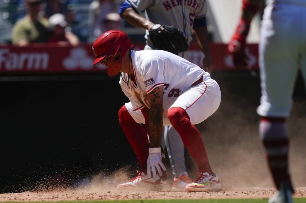 Los Angeles Angels' Zach Neto gets up after sliding home to score off a sacrifice fly hit by Kevin Pillar during the third inning of a baseball game against the New York Mets, Sunday, Aug. 4, 2024, in Anaheim, Calif. (AP Photo/Ryan Sun)