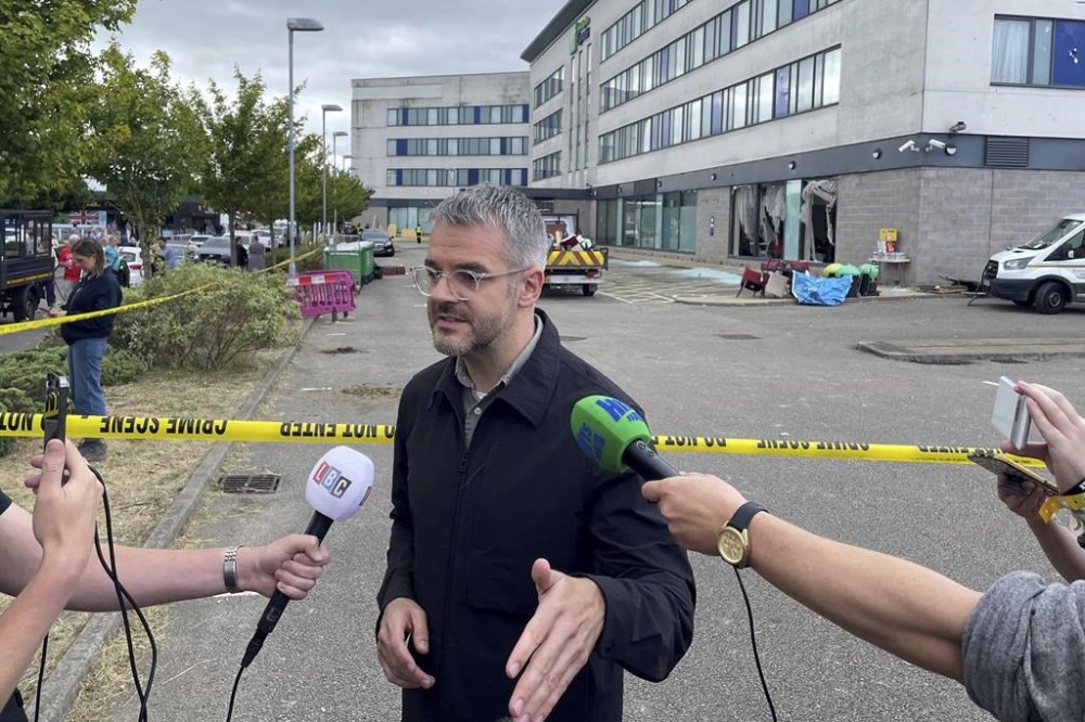 Oliver Coppard, South Yorkshire Mayor, speaks to the media outside the Holiday Inn Express where anti-immigration rioters smashed the windows before starting fires on Sunday, in Rotherham, England, Monday, Aug. 5, 2024. Lawlessness has swept the country over the past six days as right-wing activists used social media to spread misinformation to whip up anger over a stabbing rampage at a dance class that left three girls dead and many more wounded. (Dave Higgens/PA Wire/PA via AP)