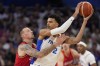 Daniel Theis, of Germany, reaches in on Victor Wembanyama, of France, in a men's basketball game at the 2024 Summer Olympics, Friday, Aug. 2, 2024, in Villeneuve-d'Ascq, France. (AP Photo/Mark J. Terrill)