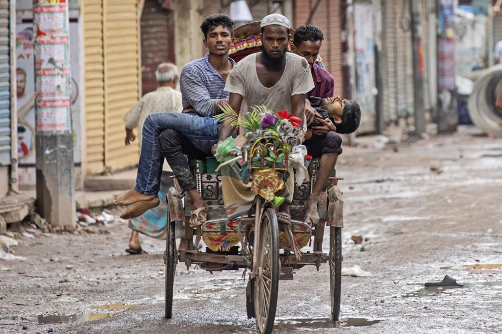 People carry an injured protester in a cycle rickshaw to a hospital after he was shot at by the police during a protest against Prime Minister Sheikh Hasina and her government, in Dhaka, Bangladesh, Monday, Aug. 5, 2024. (AP Photo/Rajib Dhar)