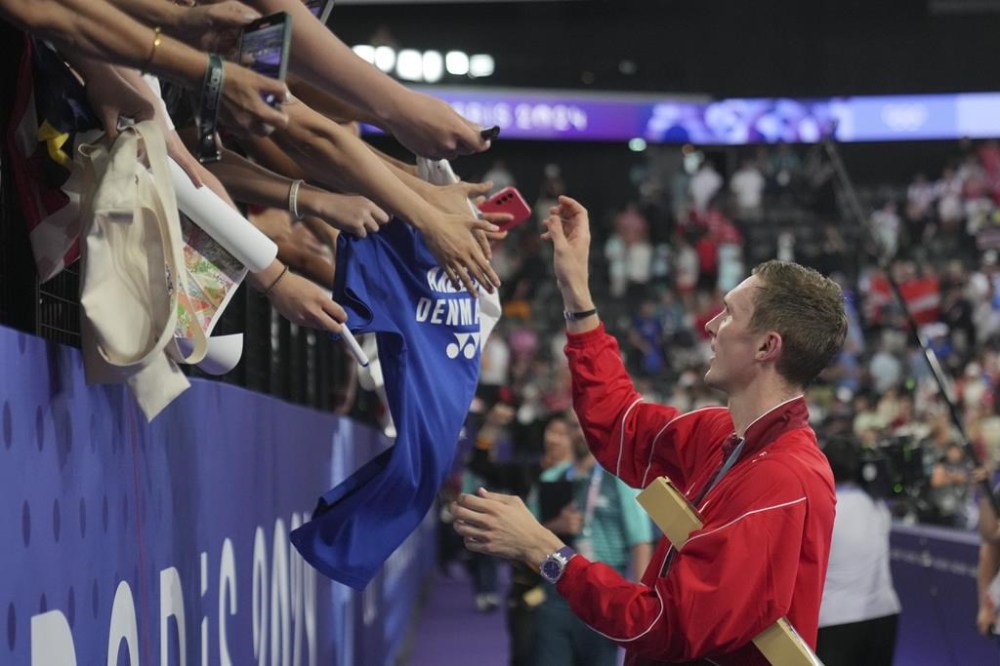 Denmark's Viktor Axelsen greets spectators after winning the gold medal at the men's singles badminton at the 2024 Summer Olympics, Monday, Aug. 5, 2024, in Paris, France. (AP Photo/Dita Alangkara)