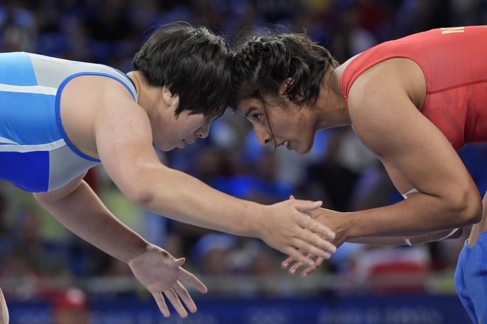 India's Nisha Nisha and North Korea's Sol Gum Pak, left, compete during their women's freestyle 68kg wrestling quarterfinal match, at Champ-de-Mars Arena, during the 2024 Summer Olympics, Monday, Aug. 5, 2024, in Paris, France. (AP Photo/Eugene Hoshiko)
