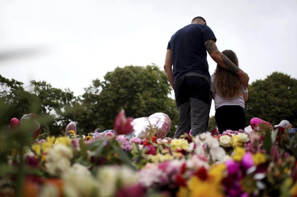 Members of the public place and look at the tributes outside the Town Hall in Southport, England, Monday Aug. 5, 2024, ahead of a vigil to remember the victims of the stabbing attack last Monday. (Ryan Jenkinson/PA via AP)