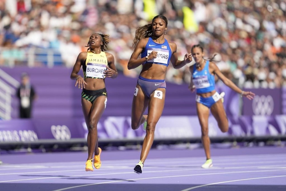 Gabrielle Thomas, of the United States, crosses the finish line to qualify in a women's 200 meters round 1 heat at the 2024 Summer Olympics, Sunday, Aug. 4, 2024, in Saint-Denis, France. (AP Photo/Ashley Landis)