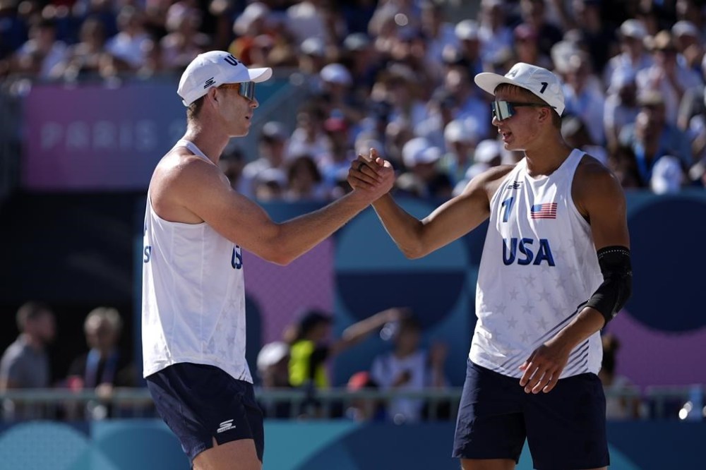 United State's Andrew Benesh, left, and Miles Partain celebrate a point in a beach volleyball match against Italy at the 2024 Summer Olympics, Monday, Aug. 5, 2024, in Paris, France. (AP Photo/Robert F. Bukaty)
