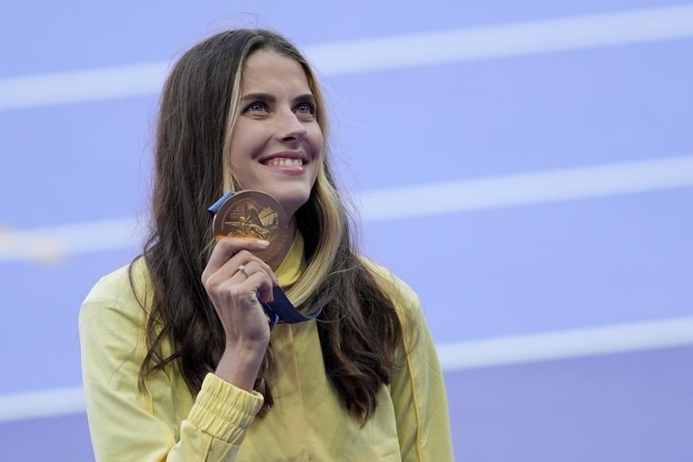 Women's high jump gold medalist Yaroslava Mahuchikh, of Ukraine, poses for a photo on the podium at the 2024 Summer Olympics, Monday, Aug. 5, 2024, in Saint-Denis, France. (AP Photo/Martin Meissner)