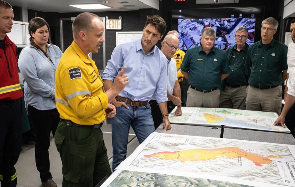 Wildfire Incident Commander Landon Shepherd, third from left, and Prime Minister Justin Trudeau speak together while visiting the wildfire command centre in Hinton, Alberta on Monday August 5, 2024. THE CANADIAN PRESS/Jason Franson
