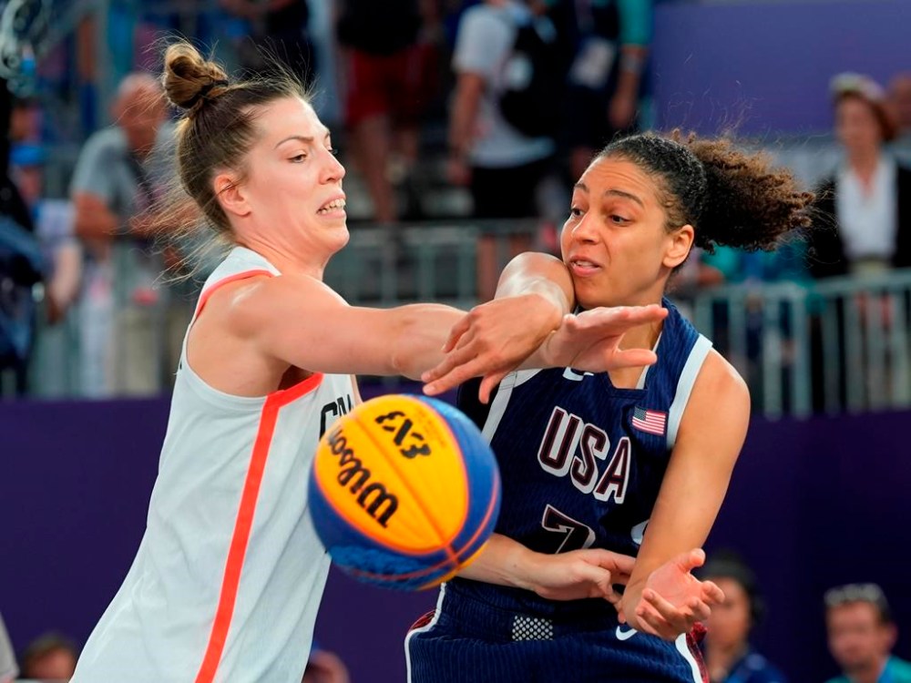 Canada's Michelle Plouffe (left) and United States Cierra Burdick (7) battle for the ball during the women's 3 X 3 basketball bronze medal game at the Summer Olympics in Paris on Monday, Aug.5, 2024. THE CANADIAN PRESS/Adrian Wyld