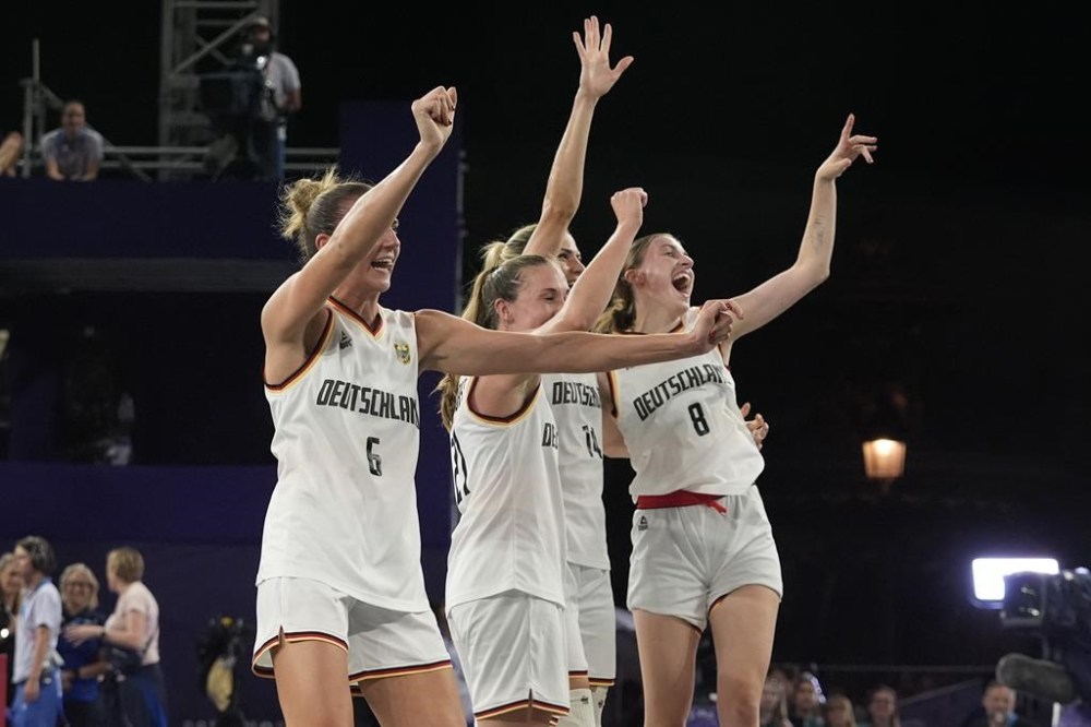 From left; Germany's Marie Reichert, Svenja Brunckhorst, Sonja Greinacher and Elisa Mevius celebrate after a women's 3x3 basketball gold medal game against Spain at the 2024 Summer Olympics, Monday, Aug. 5, 2024, in Paris, France. (AP Photo/Frank Franklin II)