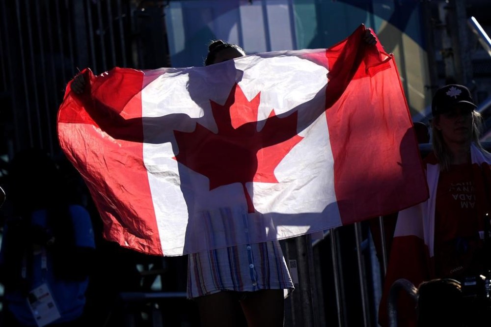 A spectator shows her patriotic support for Canada's Melissa Humana-Paredes and Brandie Wilkerson during a beach volleyball match against the United States at the 2024 Summer Olympics, Monday, Aug. 5, 2024, in Paris, France. (AP Photo/Robert F. Bukaty)