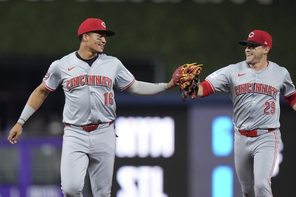 Cincinnati Reds third baseman Noelvi Marte (16) is congratulated by center fielder TJ Friedl (29) after Marte fielded a ground ball hit by Miami Marlins' Emmanuel Rivera and threw him out at first base during the fourth inning of a baseball game, Monday, Aug. 5, 2024, in Miami. (AP Photo/Wilfredo Lee)