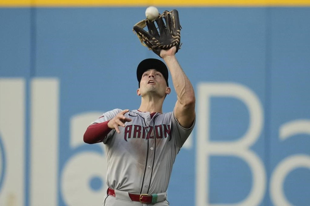 Arizona Diamondbacks right fielder Randal Grichuk catches a fly ball hit for an out by Cleveland Guardians' Lane Thomas in the fifth inning of a baseball game in Cleveland, Monday, Aug. 5, 2024. (AP Photo/Sue Ogrocki)