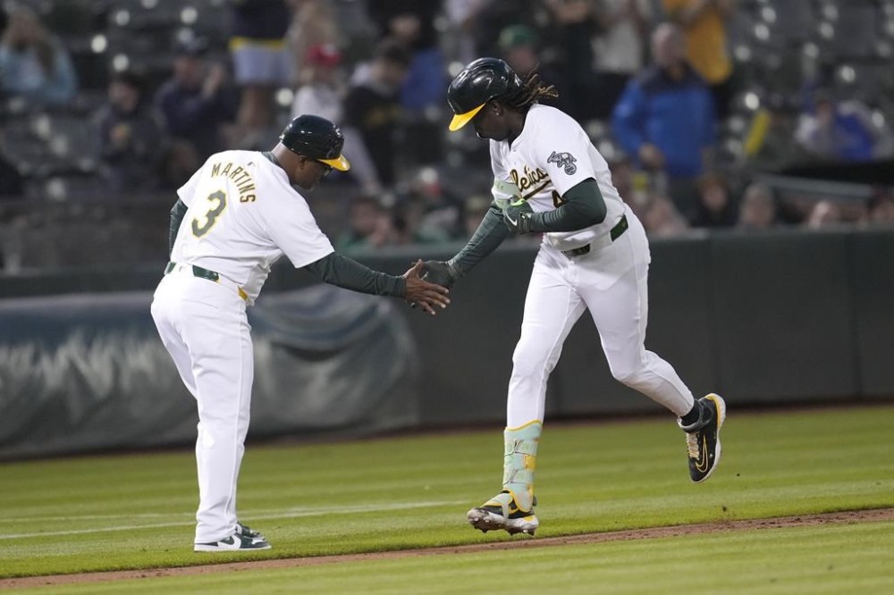 Oakland Athletics' Lawrence Butler, right, is congratulated by third base coach Eric Martins (3) after hitting a home run during the sixth inning of a baseball game against the Chicago White Sox in Oakland, Calif., Monday, Aug. 5, 2024. (AP Photo/Jeff Chiu)