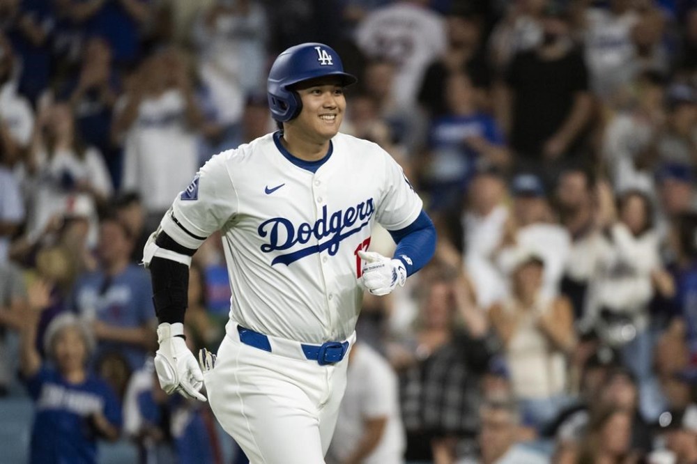 Los Angeles Dodgers' Shohei Ohtani jogs back to the dugout after hitting a solo home run during the eighth inning of a baseball game against the Philadelphia Phillies in Los Angeles, Monday, Aug. 5, 2024. (AP Photo/Kyusung Gong)