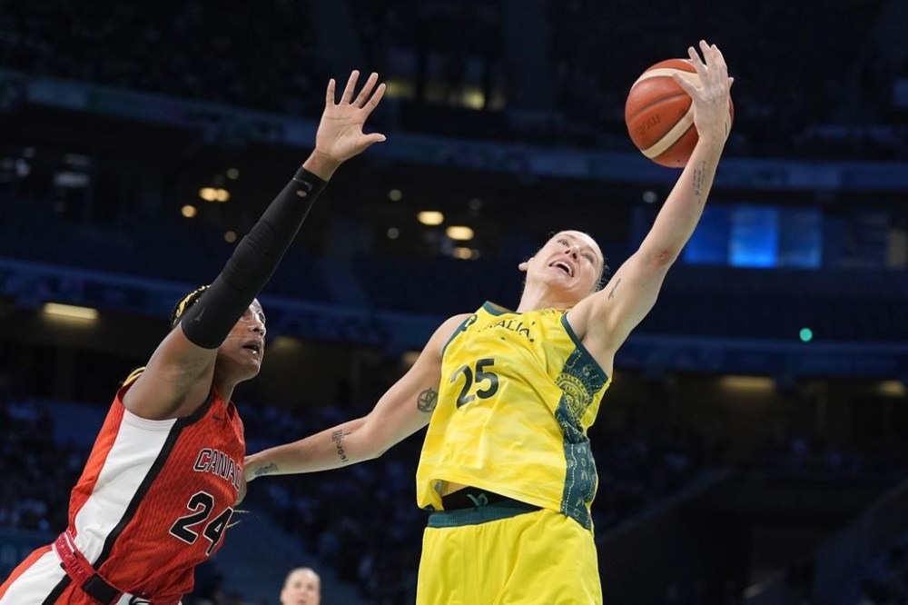 Australia's Lauren Jackson, right, reached for a rebound along with Canada's Aaliyah Edwards during a women's basketball game at the 2024 Summer Olympics, Thursday, Aug. 1, 2024, in Villeneuve-d'Ascq, France. (AP Photo/Michael Conroy)