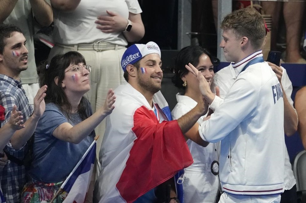 Leon Marchand of France, gestures with fans after winning the men's 200-meter individual medley final at the 2024 Summer Olympics, Friday, Aug. 2, 2024, in Nanterre, France. (AP Photo/Ashley Landis)