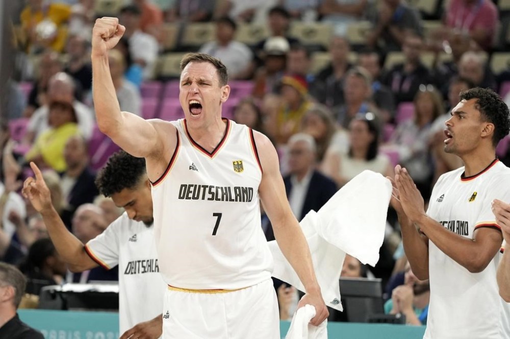 Germany's Johannes Voigtmann celebrates from the bench during a men's basketball game against Greece at the 2024 Summer Olympics, Tuesday, Aug. 6, 2024, in Villeneuve-d'Ascq, France. (AP Photo/Michael Conroy)