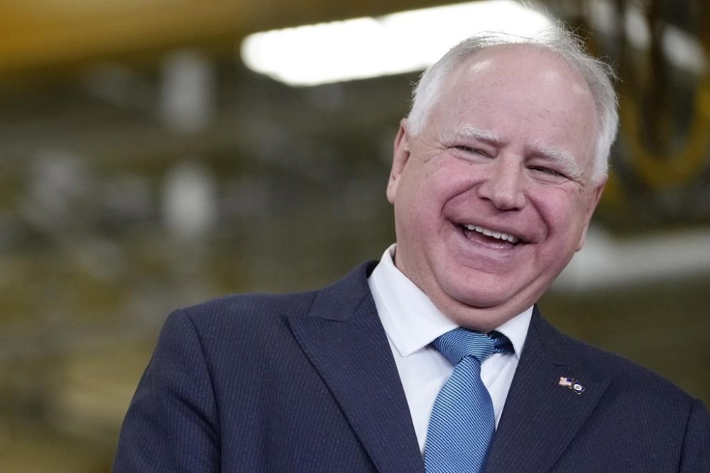 FILE - Minnesota Gov. Tim Walz, right, laughs as he stands with Fridley, Minn., Mayor Scott Lund during a visit to the Cummins Power Generation Facility in Fridley, Minn., Monday, April 3, 2023. (AP Photo/Carolyn Kaster, File)