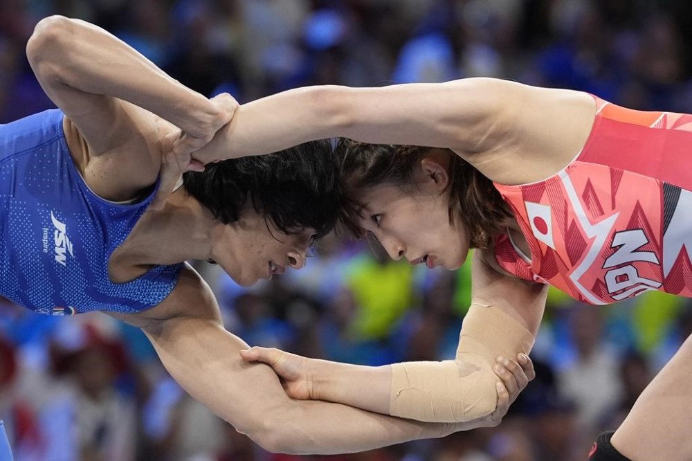 Japan's Yui Susaki and India's Vinesh Vinesh, left, compete in the round of 16 of the women's freestyle 50kg wrestling match, at Champ-de-Mars Arena, during the 2024 Summer Olympics, Tuesday, Aug. 6, 2024, in Paris, France. (AP Photo/Eugene Hoshiko)