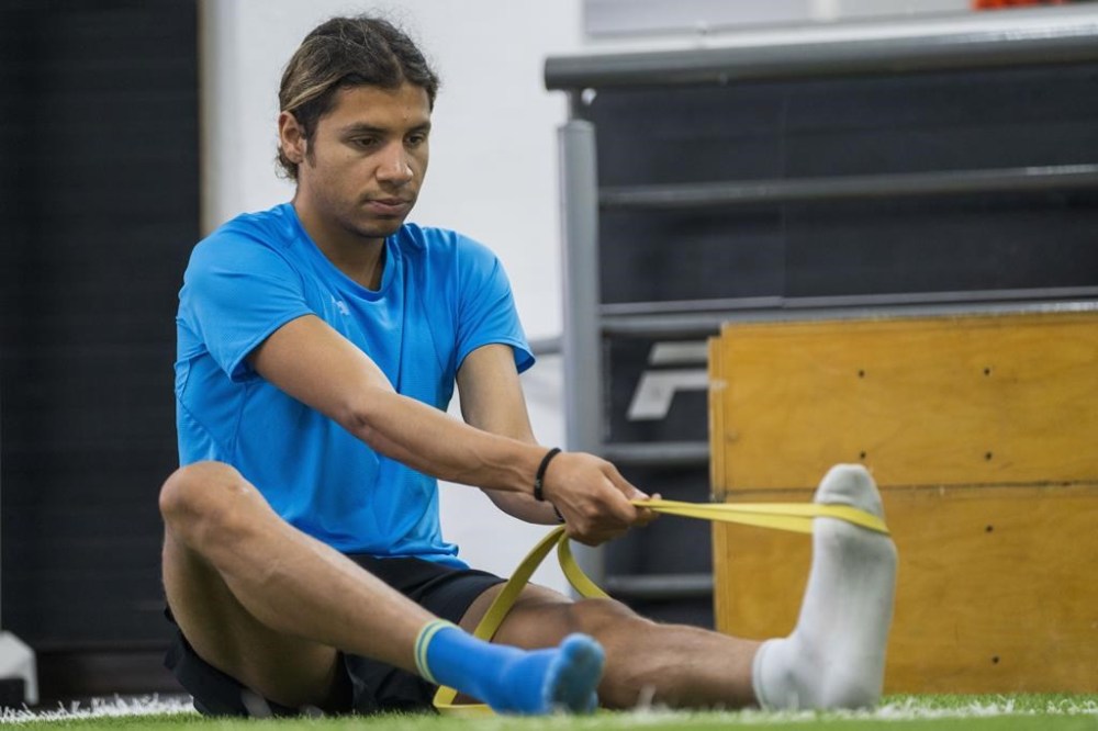 FILE - Guatemalan runner Luis Grijalva stretches during a training session at the National Stadium in Guatemala City, March 25, 2024. Grijalva is headed to the Paris 2024 Olympics to compete in the 5000-meter race. (AP Photo/Moises Castillo, File)