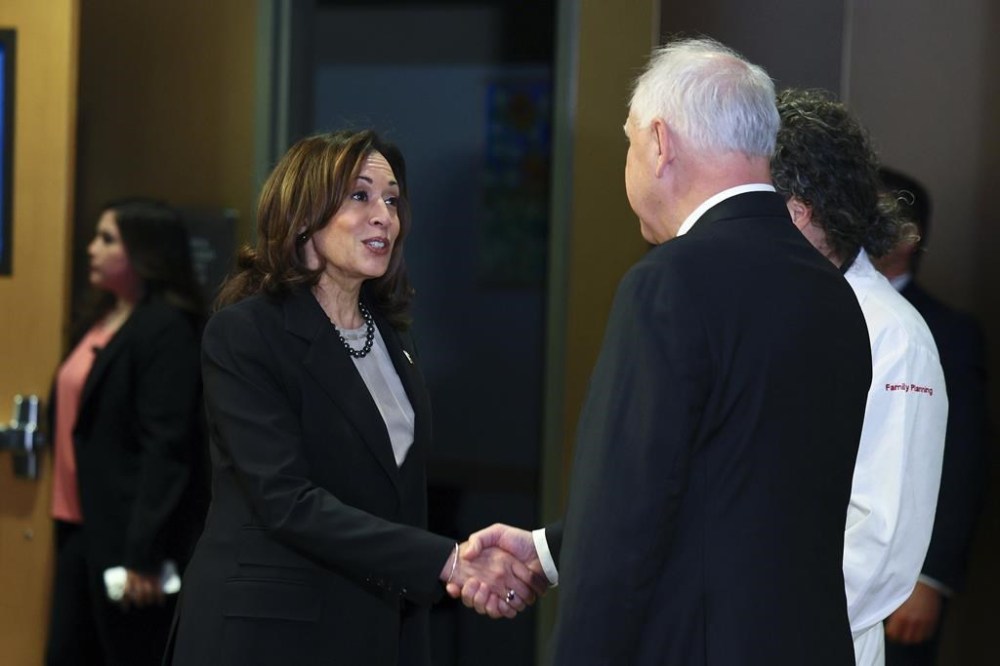 FILE - Vice President Kamala Harris greets Governor Tim Walz, right, at Planned Parenthood, March 14, 2024, in St. Paul, Minn. (AP Photo/Adam Bettcher, file )