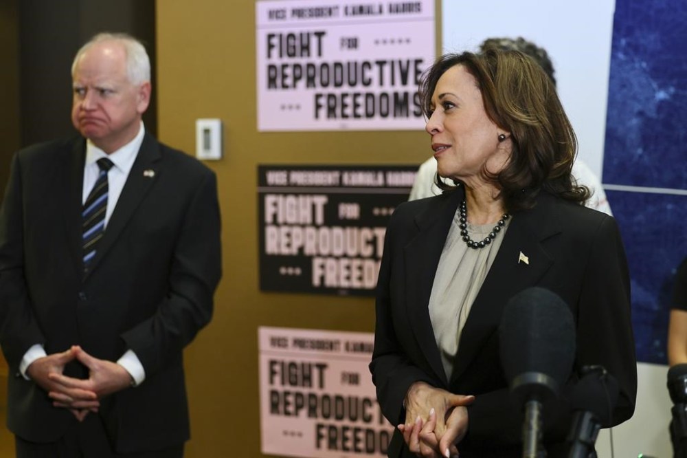 FILE - Minnesota Governor Tim Walz listens to Vice President Kamala Harris speak at Planned Parenthood, March 14, 2024, in St. Paul, Minn. (AP Photo/Adam Bettcher, File)